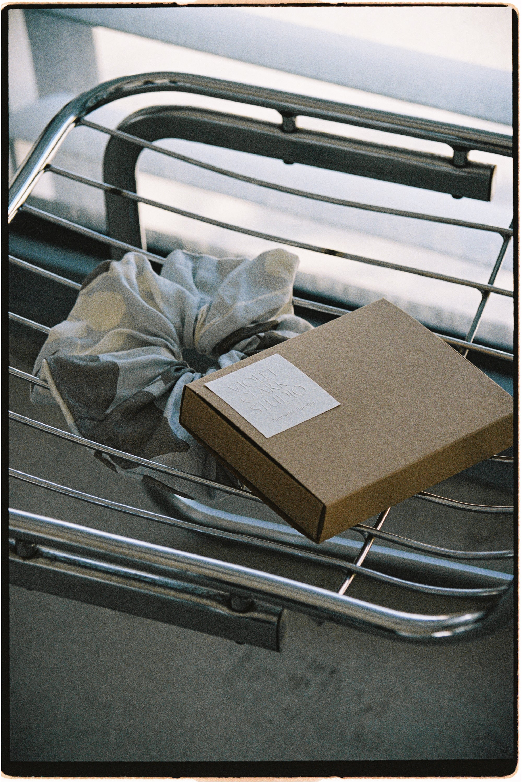 Kraft box with white embossed brand sticker.